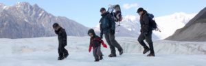 Mom, dad, and 2 kids hiking glacier in Wrangell-St. Elias National Park